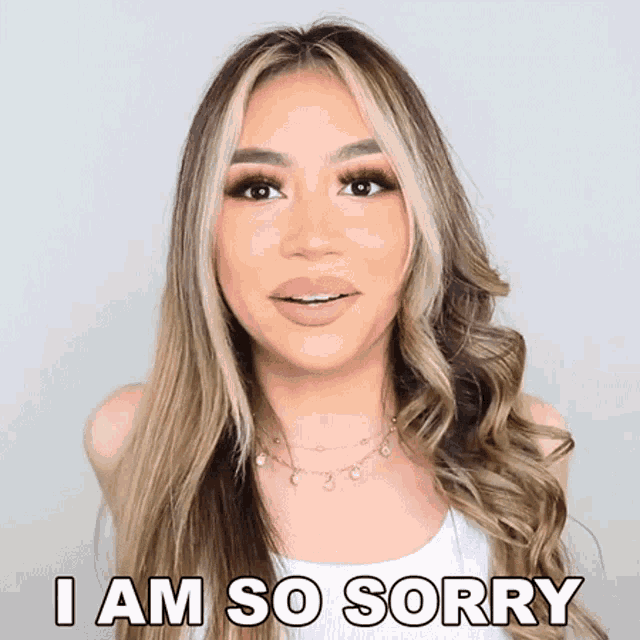 a woman with long hair is making a funny face and saying i am so sorry .
