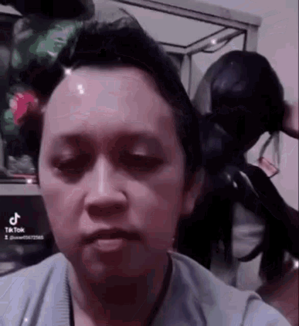a woman is making a funny face while sitting in front of a computer screen .