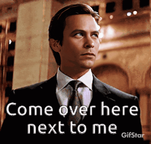 a man in a suit and tie says come over here next to me gifstar
