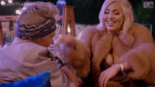 a woman in a fur coat is sitting next to a man in a headband on a tv show called ex on the beach