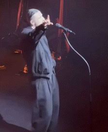 a man singing into a microphone on stage