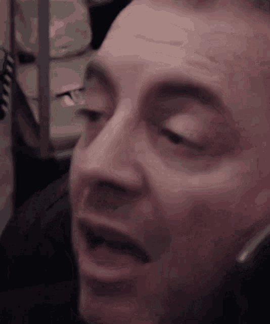 a close up of a man 's face with his mouth open while wearing headphones .
