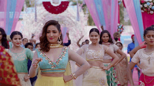 a woman in a blue top stands in a crowd of women