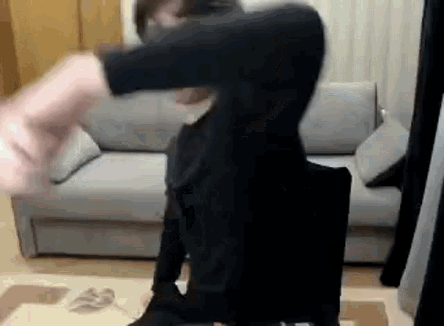 a man is sitting in a chair in front of a couch in a room .