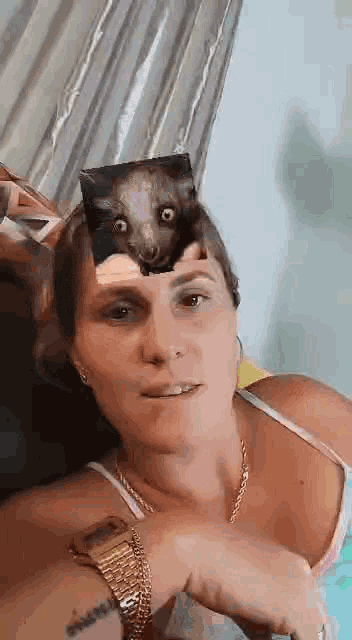 a woman wearing a watch and a picture of a bat on her head .