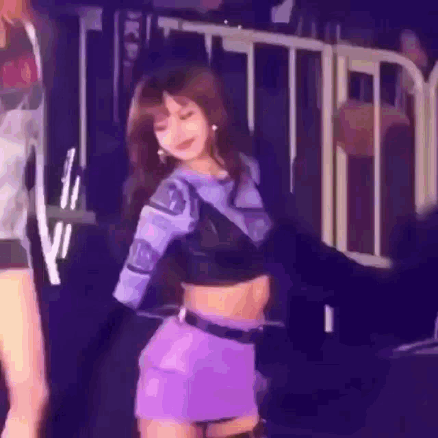 a woman in a purple skirt is dancing on stage .