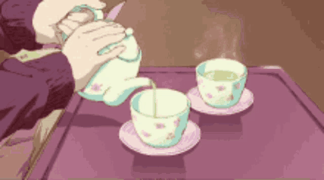 a person is pouring tea from a teapot into two cups on a table .