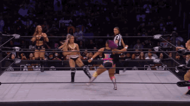 a female wrestler is kicking another wrestler in a wrestling ring that says all elite wrestling