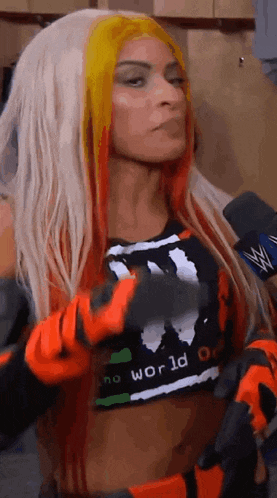 a woman with red and yellow hair is standing in a locker room .