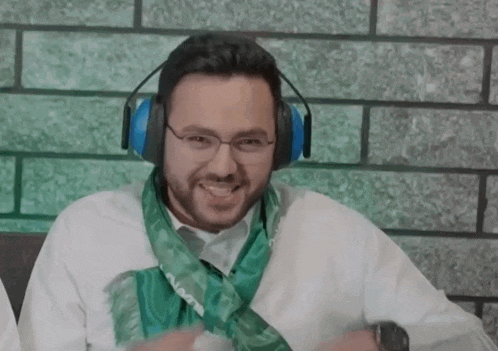 a man wearing headphones has a green scarf around his neck that says ' a ' on it