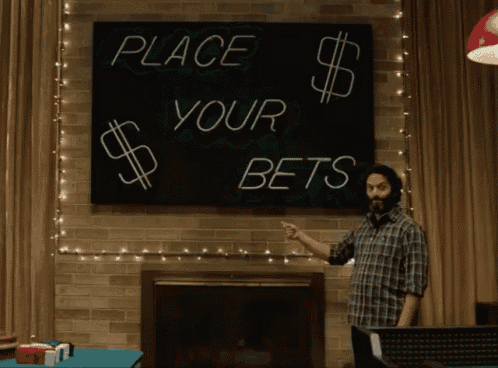 a man pointing at a sign that says place your bets