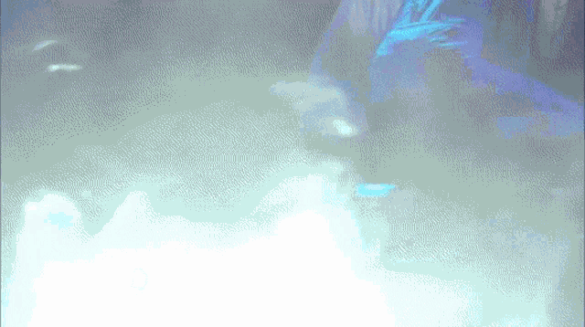 a person is standing in a dark room with a blue light shining on them