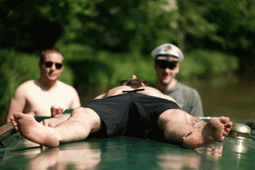 a man in a captain 's hat is laying on top of a boat