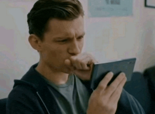 a man sitting on a couch holding a cell phone to his mouth