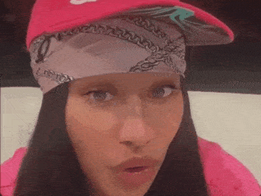 a woman wearing a pink hat and a bandana on her head .
