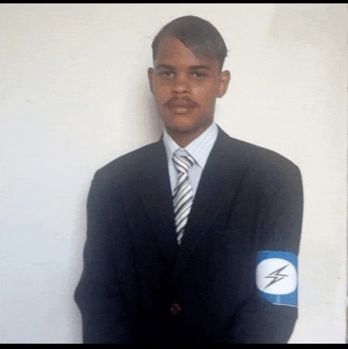 a man in a suit and tie has a blue armband with a lightning bolt on it ..