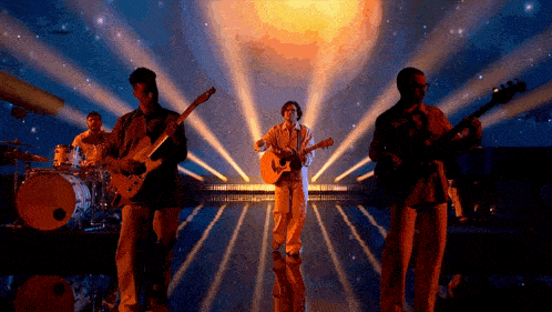 a group of men are playing guitars and singing on stage