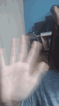 a blurry photo of a person 's hand reaching out towards the camera