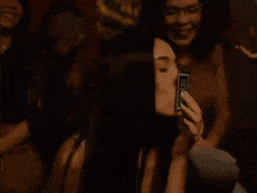 a man and woman are kissing in a dark room .
