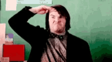 a man in a suit and bow tie is making a face