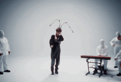 a woman in a giant ant costume is standing in front of a keyboard