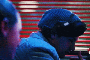 a man wearing a blue beanie is looking at something