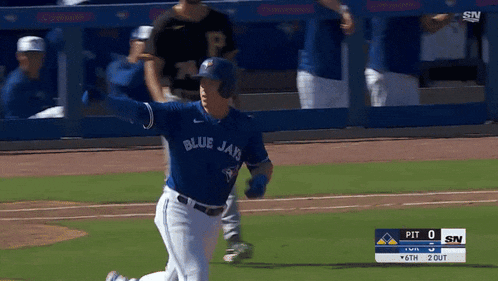 a baseball player for the blue jays is running towards home plate