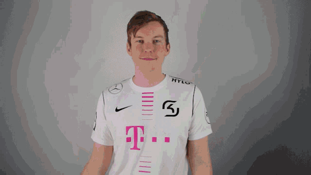 a man wearing a white shirt with a pink t on the front