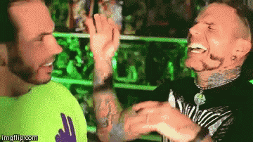 two men are giving each other a high five in front of a green light .