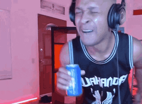 a man wearing headphones is holding a can of soda in his hand ..