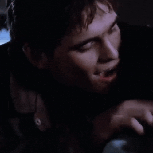a close up of a man 's face with his eyes closed and his hand on his face .