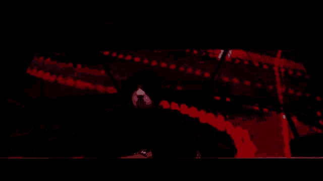 a person in a hooded sweatshirt is standing in front of a red screen