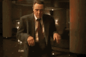 a man in a suit and tie stands in a dark room