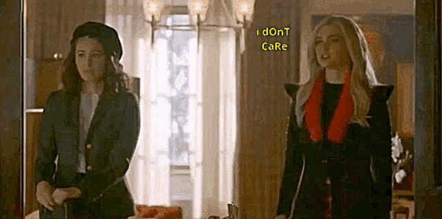 two women are standing next to each other in a room and one of them is wearing a beret .