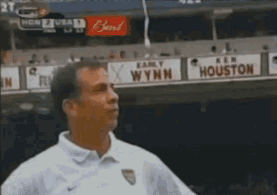 a man in a white shirt stands in front of a sign that says houston on it