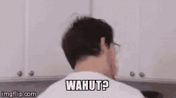 a man wearing glasses and a white shirt is making a funny face and saying wahut ?