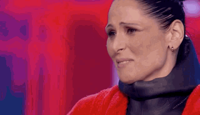 a close up of a woman wearing a red coat and a black scarf .