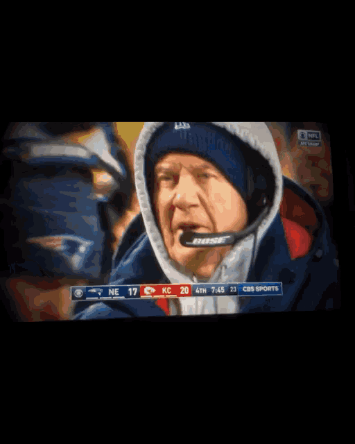 a man wearing a bose headset is watching a football game