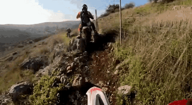 a person is riding a dirt bike on a dirt path
