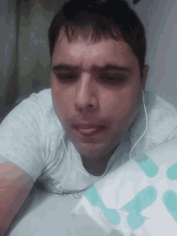 a man wearing headphones and a shirt that says ' abercrombie & fitch ' on it is laying down