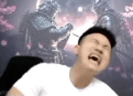a man is sitting in front of a computer screen with his mouth open while playing a video game .