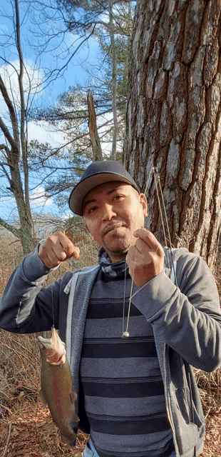 a man is holding a fish and a fishing hook