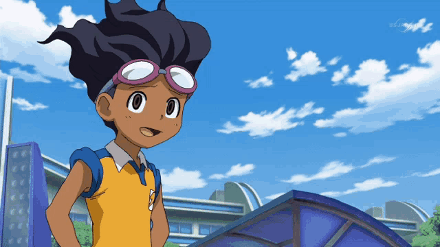a boy in a yellow shirt with the number 2 on it stands in front of a building