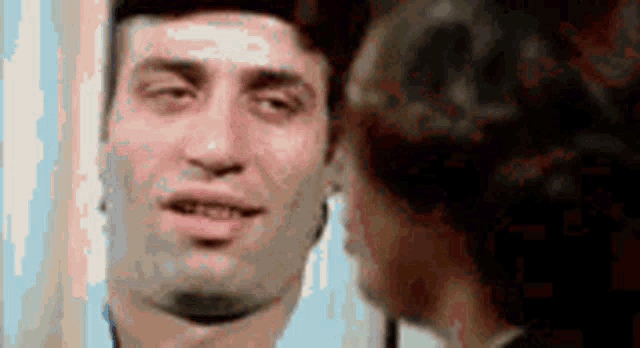 a man and a woman are looking at each other in a mirror and making funny faces .