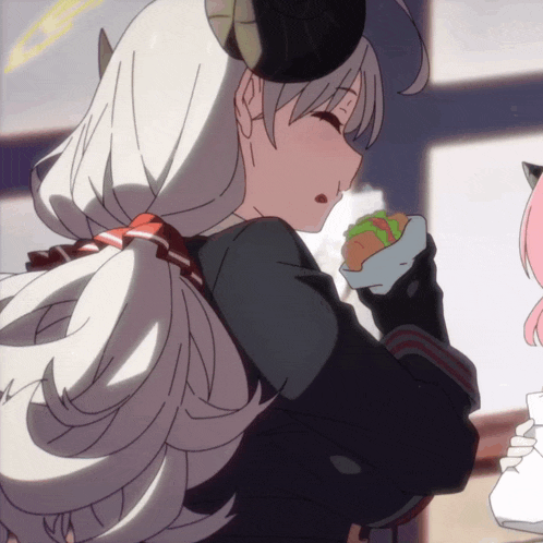 a girl with horns on her head is holding a sandwich in her hand