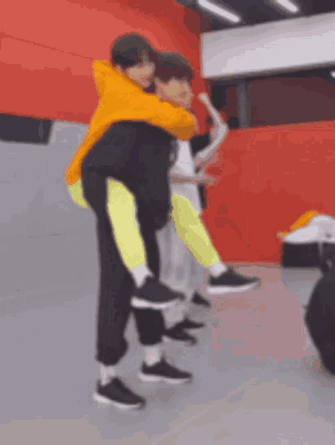 a person is carrying another person on their back in a gym .