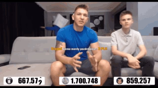 two men are sitting on a couch with the number 667,577 on the left
