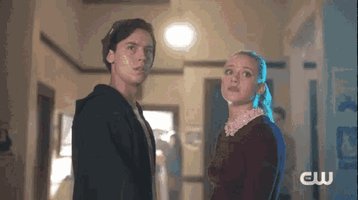 a man and a woman are looking at each other in a hallway .