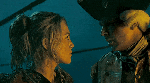 a man and a woman are looking at each other in a movie .