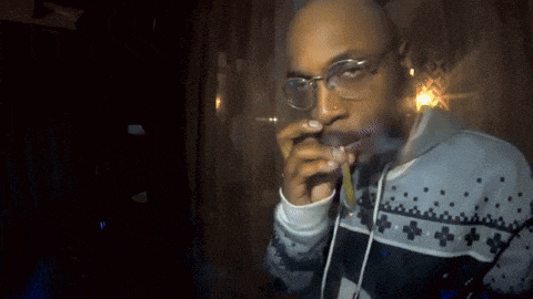 a man with glasses is smoking a cigarette